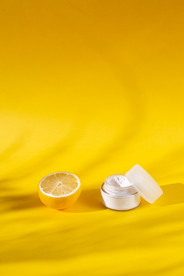 a lemon next to a small skincare container